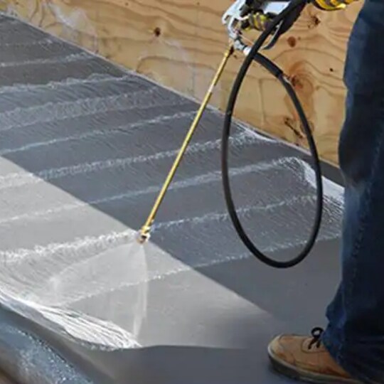 Contractor spraying EverGuard TPO Quick Spray Adhesive to save application time