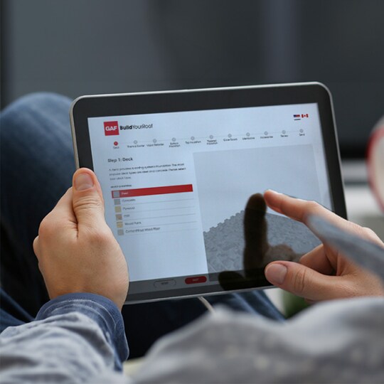 Person selecting roof system components using BuildYourRoof design tool on a tablet
