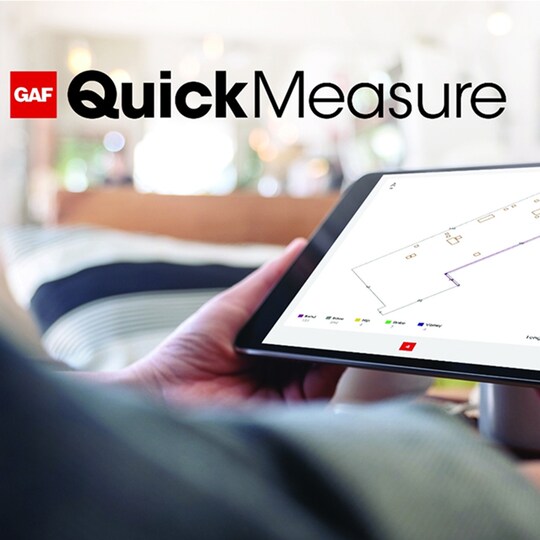 Hands holding tablet with GAF QuickMeasure roof measurements