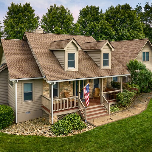 A light brown house with GAF Timberline Shakewood color shingles