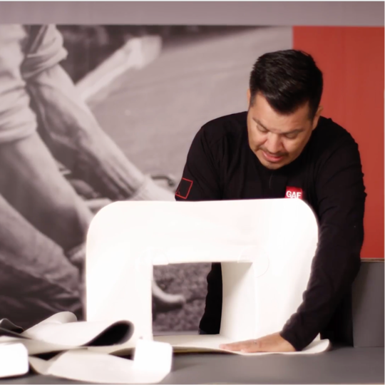 Chino Alvarado demuestra cómo instalar los accesorios prefabricados de TPO durante una presentación de capacitación.