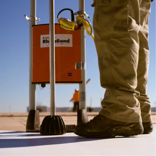 A GAF certified contractor using a induction welder on a roof deck.