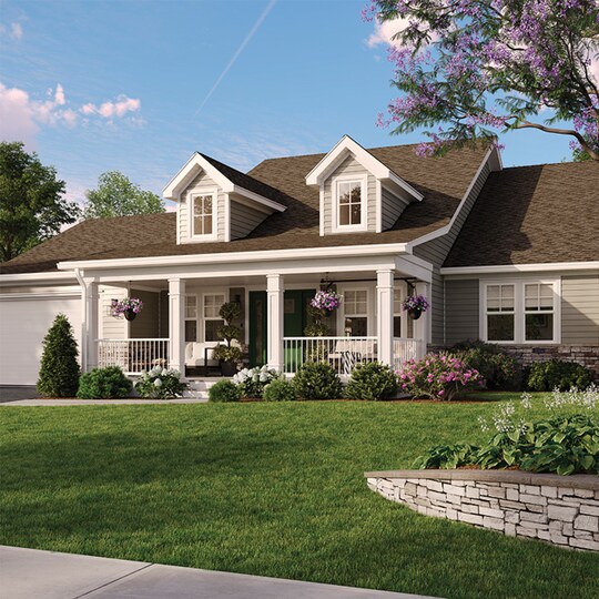 A one story, light grey-sided home with a white porch and dark brown shingles from GAF is set against a sunny, landscaped yard.