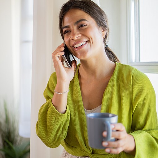 A woman talking to a GAF representative on the phone to get information about roofing contractors