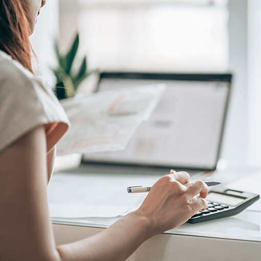 A homeowner using a calculator to calculate potential incentives and savings through government programs. 