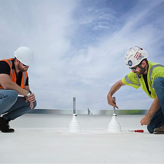 Two roofing contractors on a commercial roof at work