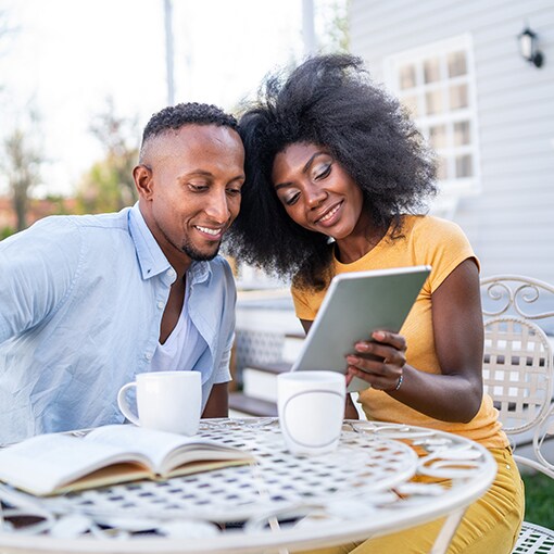 A couple checks their lowered energy bill after getting a TImberline Solar Roof System installed on their home.  