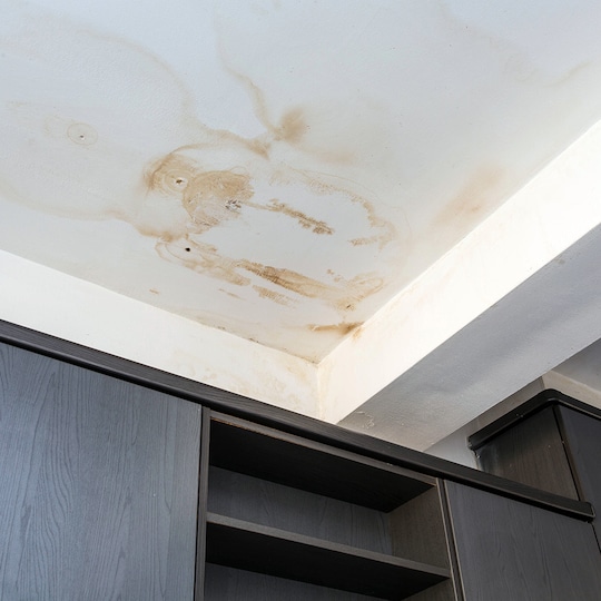 Water stains on a white ceiling, suggesting roof leaks. 