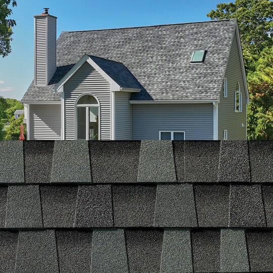 GAF Timberline HDZ® Cliffside Shingle closeup with sample product image on a light blue house.