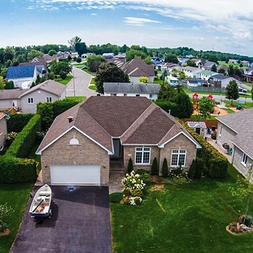  Aerial drone view of residential house roofs in a suburban neighborhood.