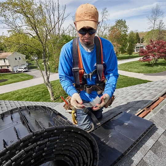 A roofer installing a ridge vent