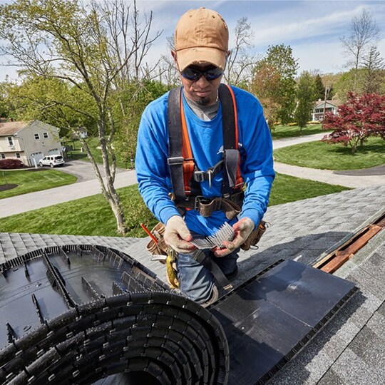 A roofer installing a ridge vent