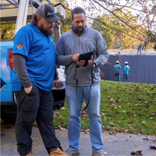 Contractors using GAF ScopeConnect on tablet for roofing insurance restoration projects