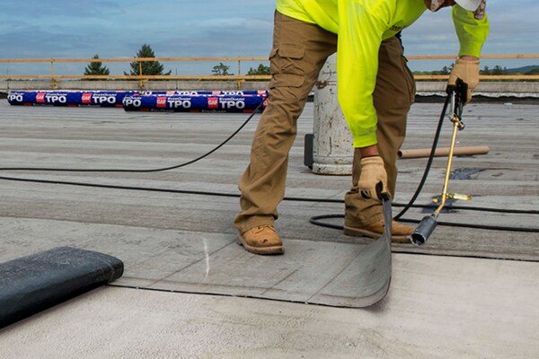 Roofer installing a hybrid roof system
