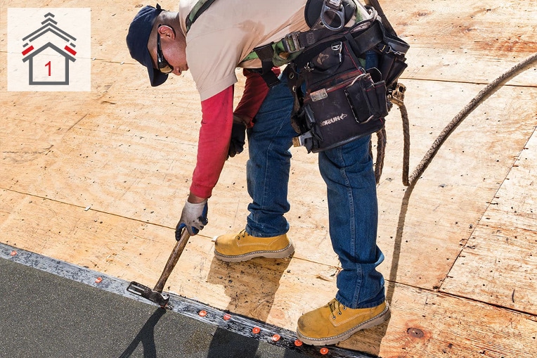 Contratista de techado instalando una barrera contra goteras de GAF 
