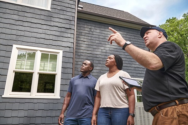 A contractor speaks with homeowners about additional services, now that a Territory Manager has confirmed those services are available in their area.