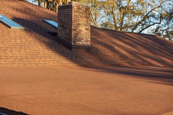 Roof with a chimney with a self-adhering roofing system