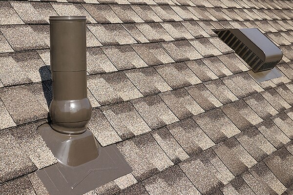 A close-up view of an asphalt shingle roof featuring GAF roof accessories that can help reduce water penetration. 