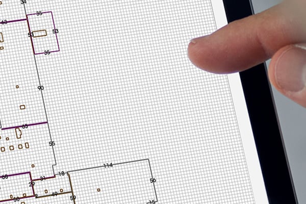  Architects’s finger tapping on a screen showing grid paper