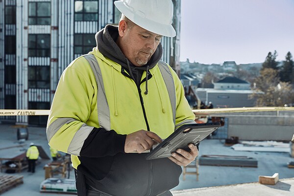 Commercial contractor looking down at ipad to view the Maintenance Checklist