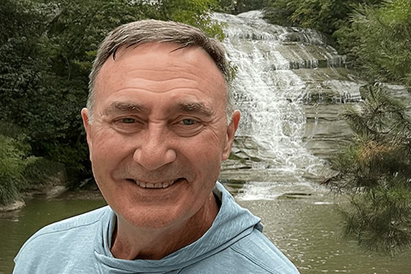 A man standing in front of a waterfall