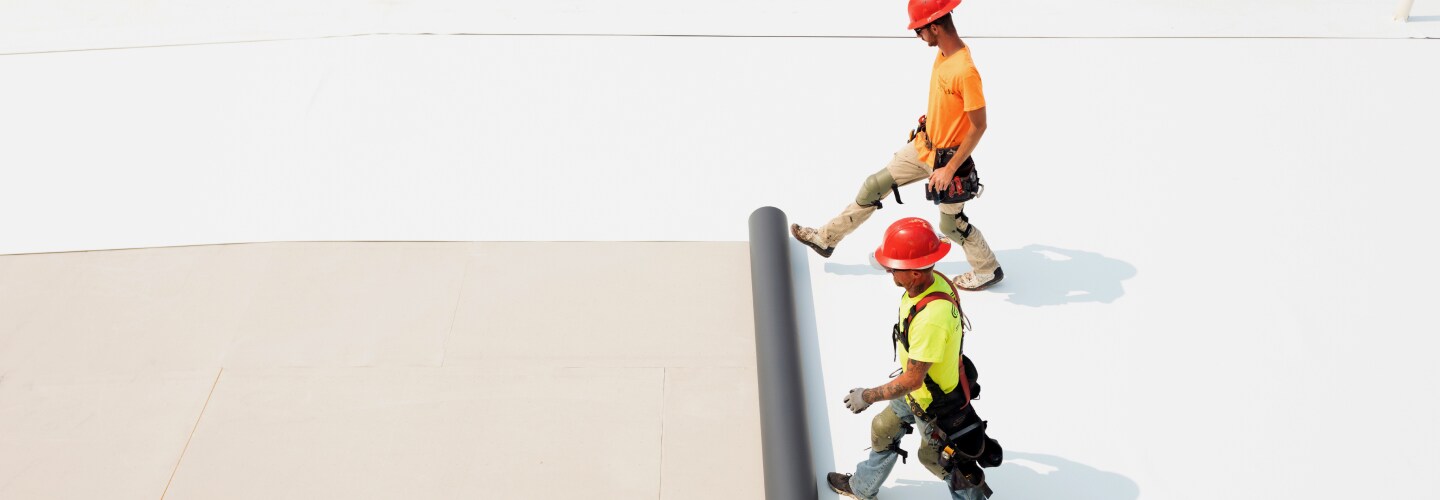 Roofing contractor laying GAF vapor barrier.