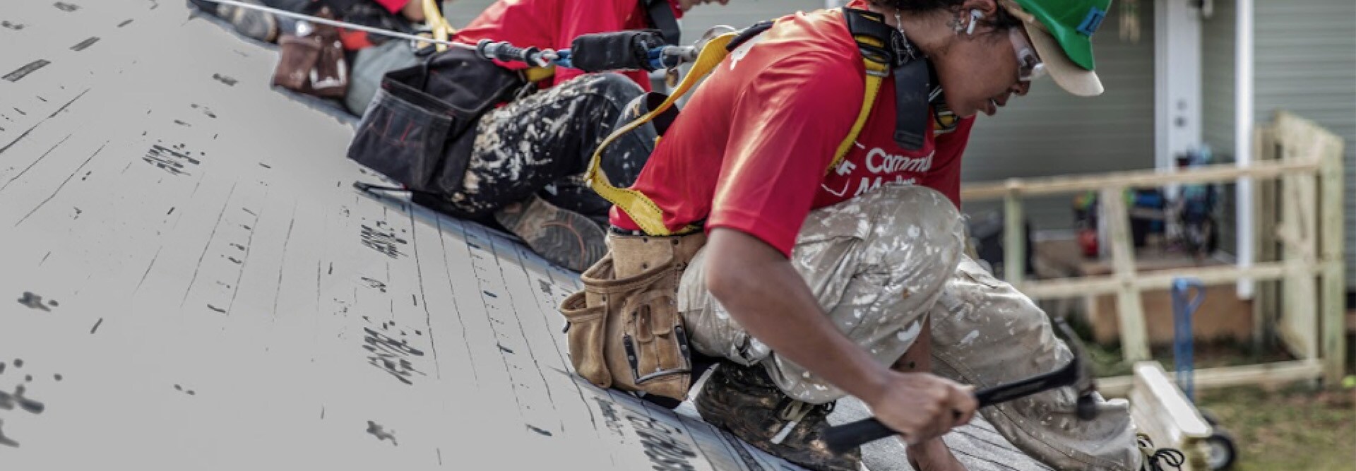 Roofers in the GAF Community Contractor Program installing materials on top of a house. 