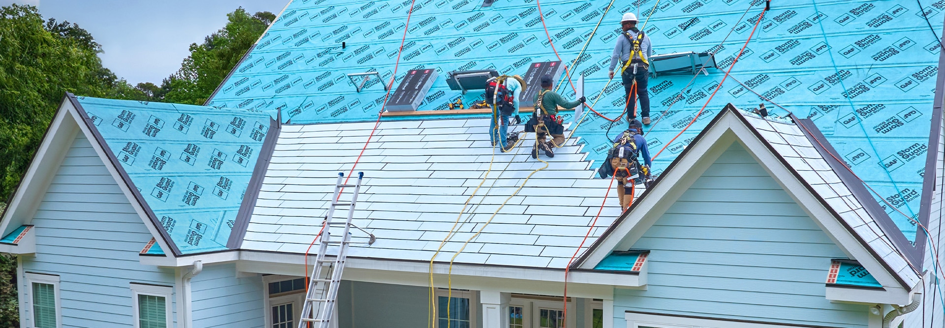 GAF certified contractors standing on a rooftop installing the TimberSteel Metal Roofing System. 