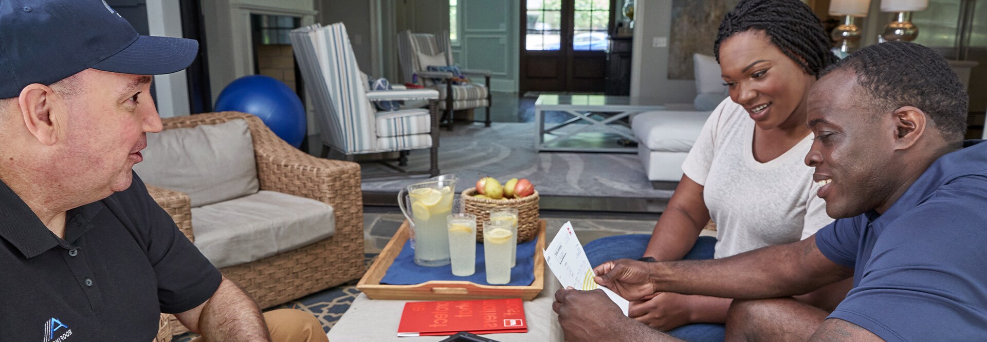 Homeowners reviewing roof replacement options with a GAF roofing contractor