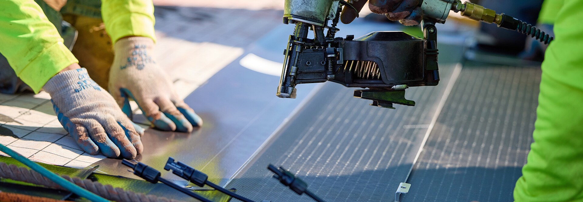Two solar certified contractors installing a Timberline Solar roofing system on a roof. 