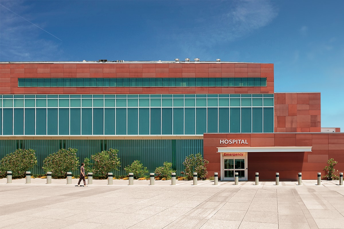 the front of a hospital featuring a complex roof