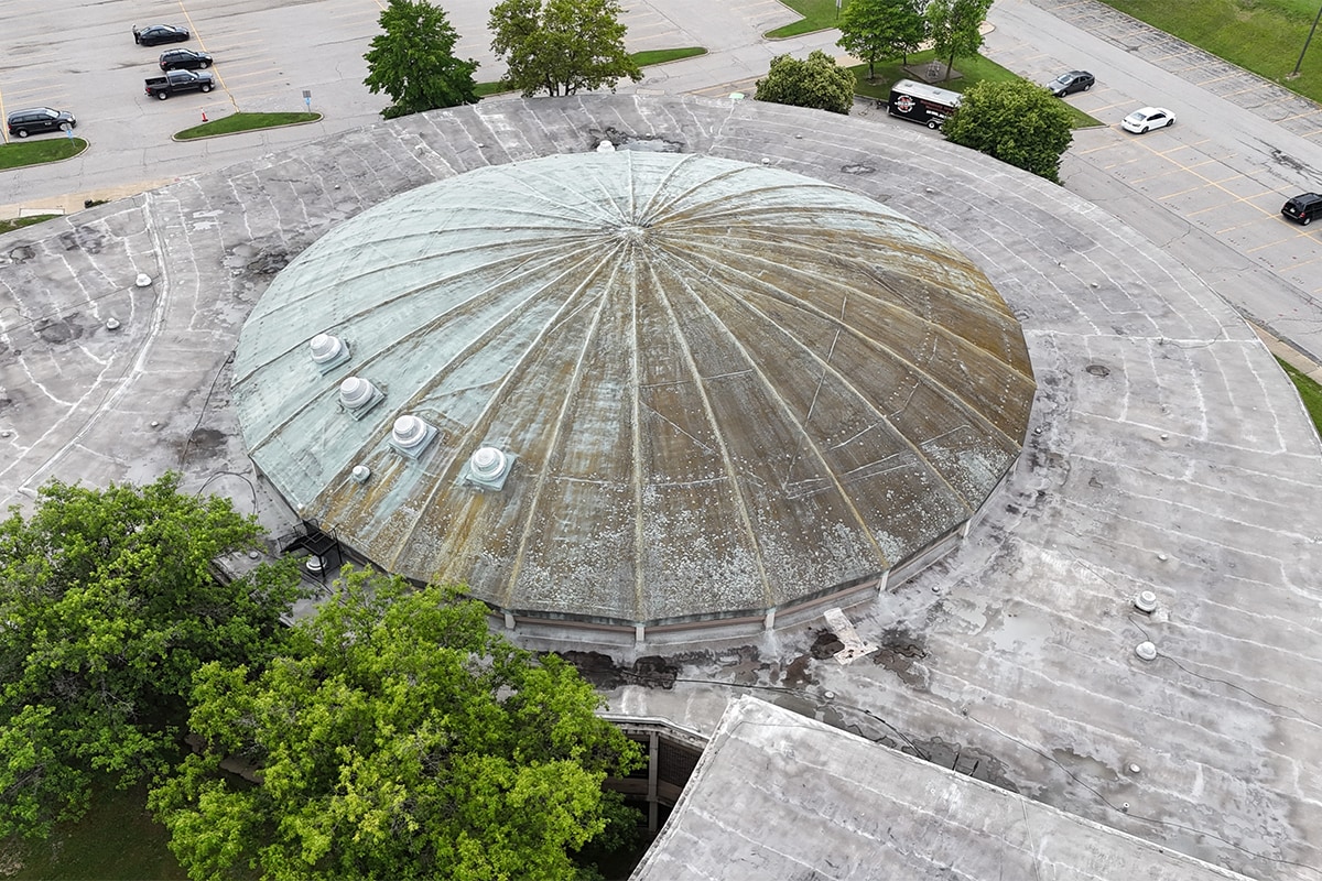 Aerial view showing aging dome roof with mixed patina green and weathered areas before restoration at Normandy High School in Parma, OH