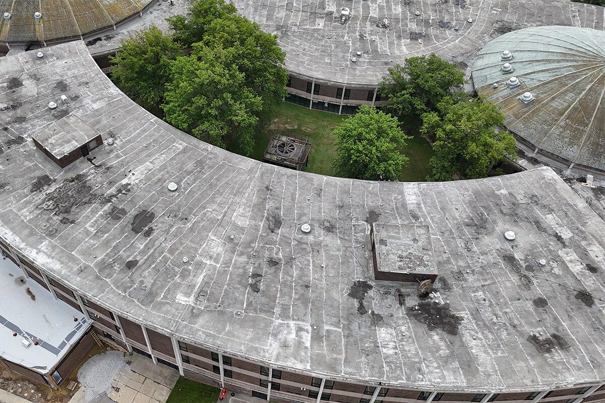 Before image of the flat roof and dome showing aging roofing materials with visible wear at Normandy High School