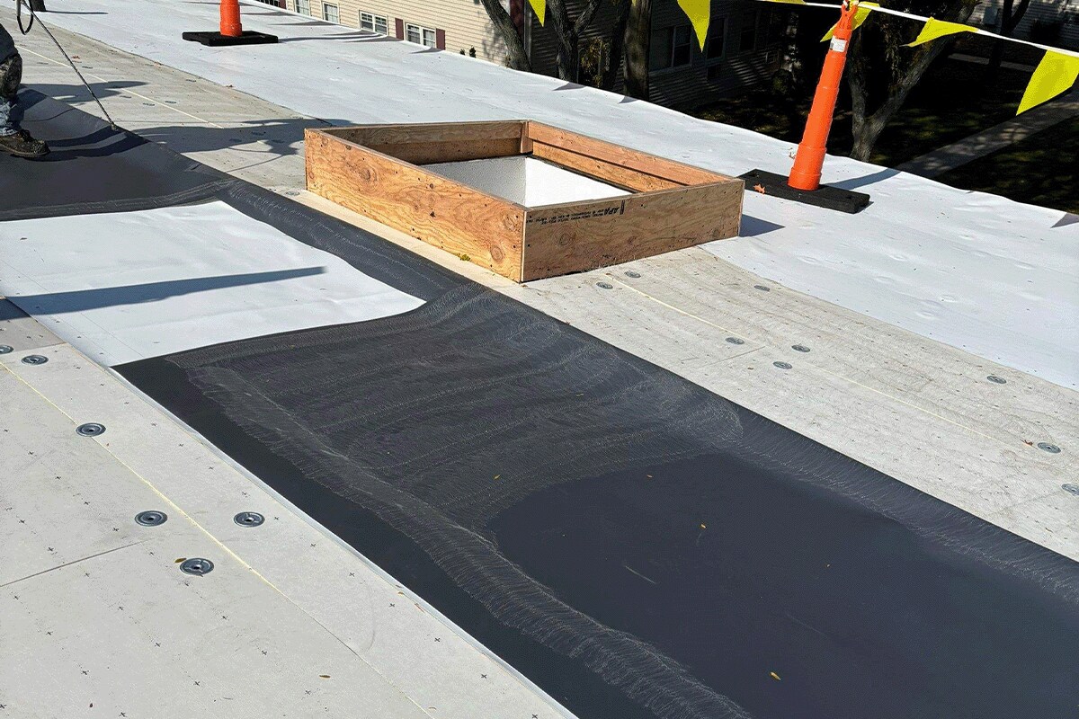 A GAF flat roof recovery system is being installed on the Post House, a HOA community of 12 buildings.