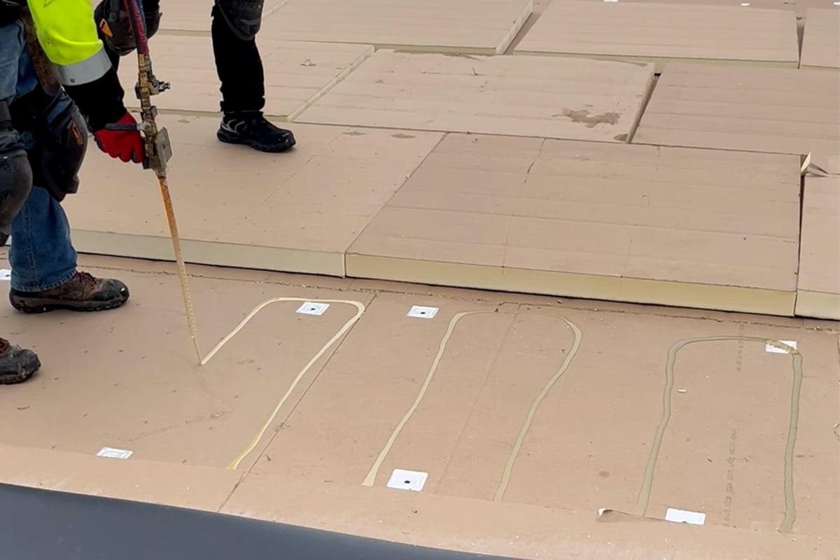 Roofing contractors working on the roof of the Wisconsin Saputo Cheese facility