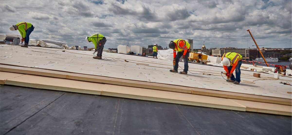 Side view of contractors adhering commerical roof on Savannah Convention Center