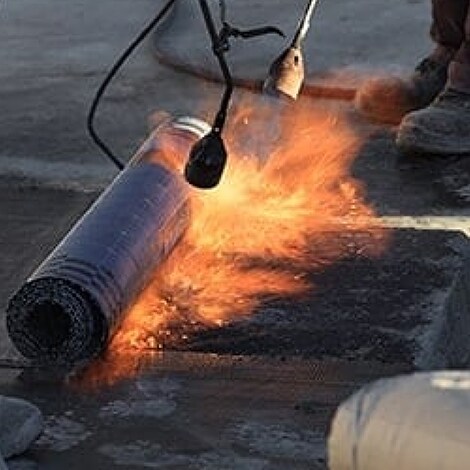 Contractor applying Mod Bit APP roofing system 