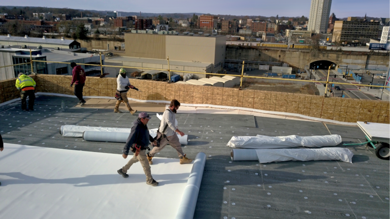 Aerial shot of GAF certified contractors installing a commercial roof system.