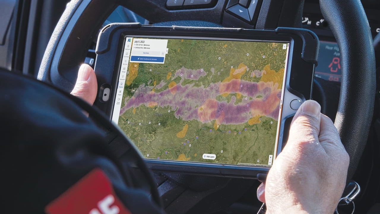 Hand holding tablet with GAF WeatherHub storm map