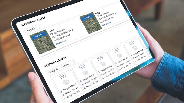 Hands holding tablet open to My Weather Alerts to plan your roofing jobs