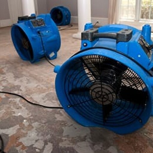 Powerful fans drying out wet areas of a home after hurricane damage
