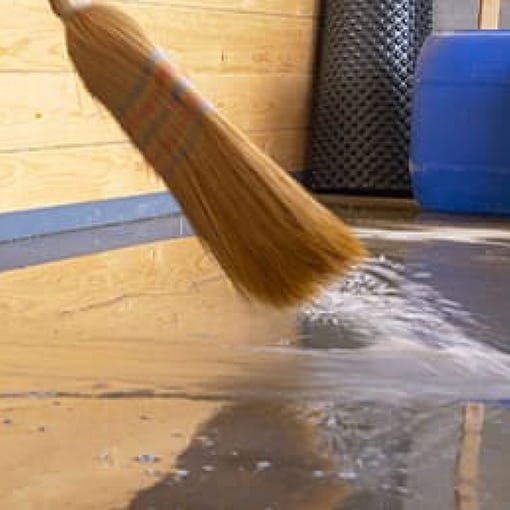 Brush sweeping water left at a home by a storm